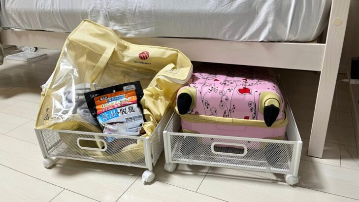 ベッド下にキャスター付き収納とキャリーケースを収めた様子