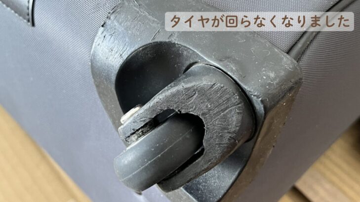 壊れたキャリーバッグの車輪のクローズアップ