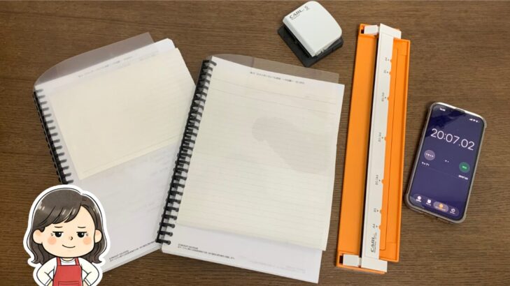 印刷したスタサプテキストをバインダーに綴じる製本作業の様子。ノート・バインダー・穴あけパンチ・タイマー（20分7秒）写真と母のイラスト